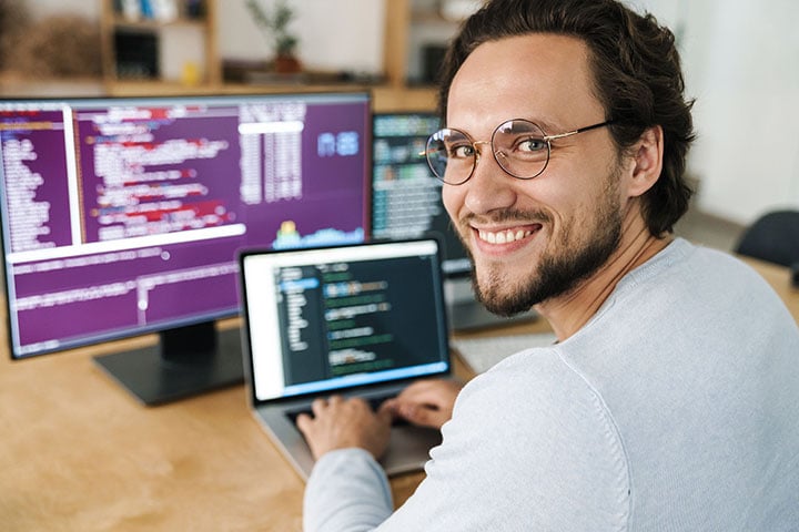 720 DEMICON image-of-programmer-man-wearing-eyeglasses-working-AKDKPWB